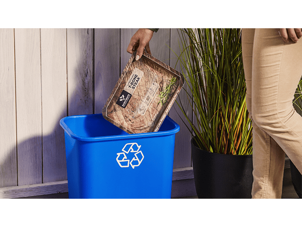 Tray being placed in recycling bin