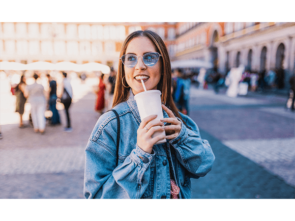 Woman on street with cold cup